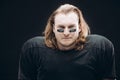Determined American football player posing with painted face and chewing gum Royalty Free Stock Photo