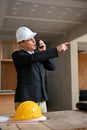 Determined Caucasian businessman using a walkie-talkie to command his workers