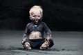 Portrait of dirty child on the black san beach