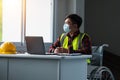 Portrait disabled person sitting on wheelchair wear mask working in the office