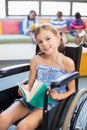 Portrait of disabled school girl reading book in library Royalty Free Stock Photo