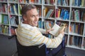 Portrait of disabled school teacher holding book in library Royalty Free Stock Photo