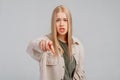 Portrait of disappointed angry young blonde woman frowning wearing casual clothes, pointing index finger at camera, being mad,