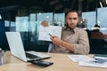 Portrait disappointed businessman inside office, african american man showing document graph with bad financial