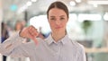 Portrait of Disappointed Young Woman doing Thumbs Down Sign Royalty Free Stock Photo