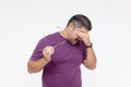 Portrait of a disgraced middle aged man in a purple shirt taking off his glasses, looking depressed. Studio shot on a white Royalty Free Stock Photo