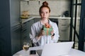 Portrait of disgruntled frustrated young woman holding present gift box during video call via laptop