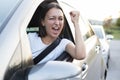 Angry woman driving a car gesturing with rudeness