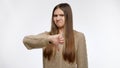 Portrait of displeased girl showing thumb down gesture over white studio background Royalty Free Stock Photo