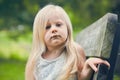 Portrait of displeased little girl sitting on bench Royalty Free Stock Photo