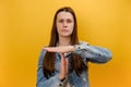 Portrait of displeased young caucasian woman showing time out hand gesture, looking imploringly, worried about deadline, wearing