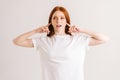 Portrait of displeased young woman covering her ears and gesticulating say no bla-bla-bla standing on white isolated Royalty Free Stock Photo