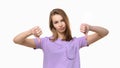 Portrait of displeased young woman showing thumbs down gesture on white background Royalty Free Stock Photo