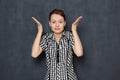 Portrait of dissatisfied girl raising hands and being indignant