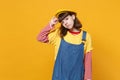 Portrait of dissatisfied sad girl teenager in french beret, denim sundress looking aside isolated on yellow wall Royalty Free Stock Photo