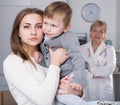 Portrait of dissatisfied woman with her child after visiting clinic