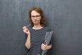 Portrait of dissatisfied young woman holding folder and pen Royalty Free Stock Photo