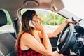 Young beautiful reckless woman using smartphone while driving car Royalty Free Stock Photo