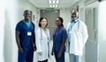 Portrait of diverse group of four doctors and healthcare workers smiling in hospital corridor Royalty Free Stock Photo