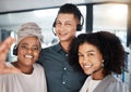 Portrait of a diverse group of happy smiling call centre telemarketing agents taking selfies together in an office Royalty Free Stock Photo