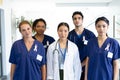 Portrait of diverse group of healthcare workers wearing cancer ribbons standing in hospital corridor Royalty Free Stock Photo