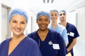 Portrait of diverse group of healthcare workers wearing surgical caps smiling in hospital corridor Royalty Free Stock Photo