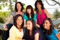 Diverse group of mothers and daughters laughing and smiling.