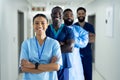 Portrait of diverse group of smiling healthcare workers standing in line in hospital corridor Royalty Free Stock Photo