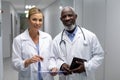 Portrait of diverse male and female doctors standing in hospital corridor smiling to camera Royalty Free Stock Photo