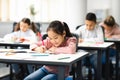 Portrait of diverse schoolchildren sitting in classroom writing and drawing Royalty Free Stock Photo