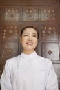 Portrait of Doctor In Front of Traditional Chinese Medicine Cabinet Royalty Free Stock Photo