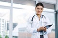 Portrait, doctor and happy woman with tablet in hospital for research, telehealth or healthcare. Face, smile and female Royalty Free Stock Photo