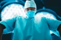 Portrait of a doctor in a mask on a background of surgical lamps. Medicine concept