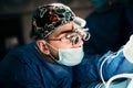 Close up portrait of doctor performing surgery operation in sterile surgery room