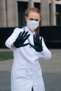 A portrait of a doctor`s girl wearing a medical mask shows a sign of prohibition Royalty Free Stock Photo