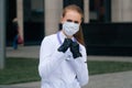 A portrait of a doctor`s girl wearing a medical mask shows a sign of prohibition Royalty Free Stock Photo