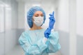 Portrait of doctor in scrubs. A female doctor in a protective cap and face mask in safety measures against the coronavirus