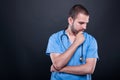 Portrait of doctor wearing scrubs with stethoscope thinking Royalty Free Stock Photo