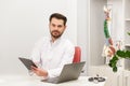 Portrait of doctor in white coat at workplace with medical staff on the background. Male doctor working at office desk Royalty Free Stock Photo