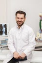 Portrait of doctor in white coat at workplace with medical staff on the background. Male doctor working at office desk Royalty Free Stock Photo