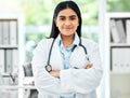 Portrait of a doctor working in her office with medical equipment at a modern surgery center. Happy healthcare worker