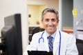 Portrait Of Doctor Working At Nurses Station