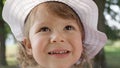 CLOSE UP: Beautiful toddler with lovely smile laughing while she plays in nature Royalty Free Stock Photo