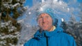 PORTRAIT, DOF: Squinting male tourist gets hit in the face by a fluffy snowball.