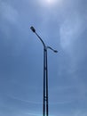 A double-headed street lamp standing under the clear sky