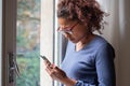 Portrait of doubtful black woman standing beside window Royalty Free Stock Photo