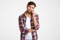 Portrait of a doubtful young man talking on mobile phone Royalty Free Stock Photo