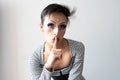 portrait of drag queen and lgbti doing the silence sign in front of white background