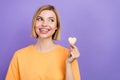 Portrait of dreaming lovely lady blonde hair woman looking empty space eating sweet cookie heart shape isolated on Royalty Free Stock Photo