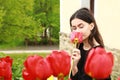 Portrait of dreaming pretty young teen girl behind red tulips